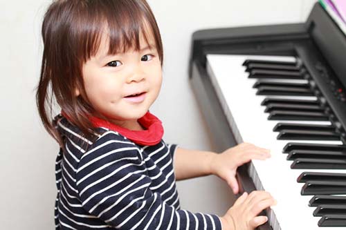 Small girl playing a piano.